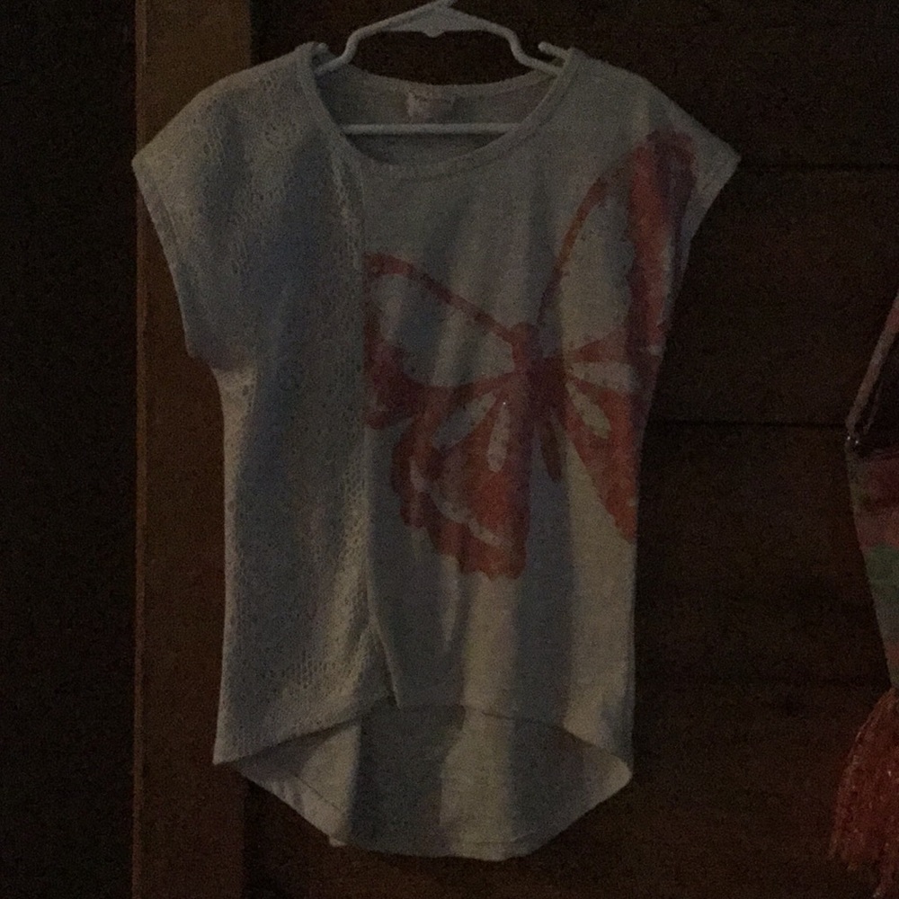 An off white t-shirt with butterfly on it.
