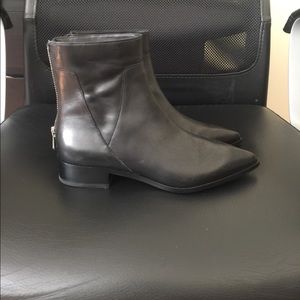 Black leather pointed Chelsea boots.