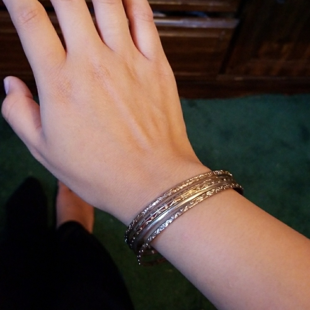 4 Gold tone bangle bracelets with design
