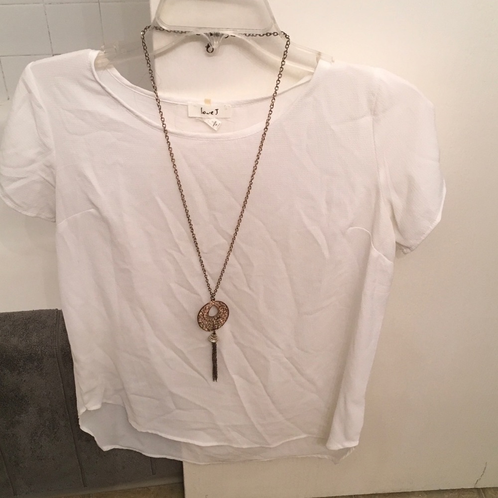 A white/cream colored blouse with gold necklace