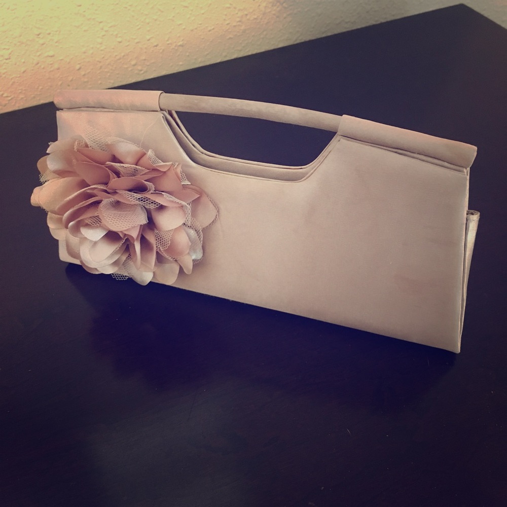 Champagne colored clutch with flower accent.