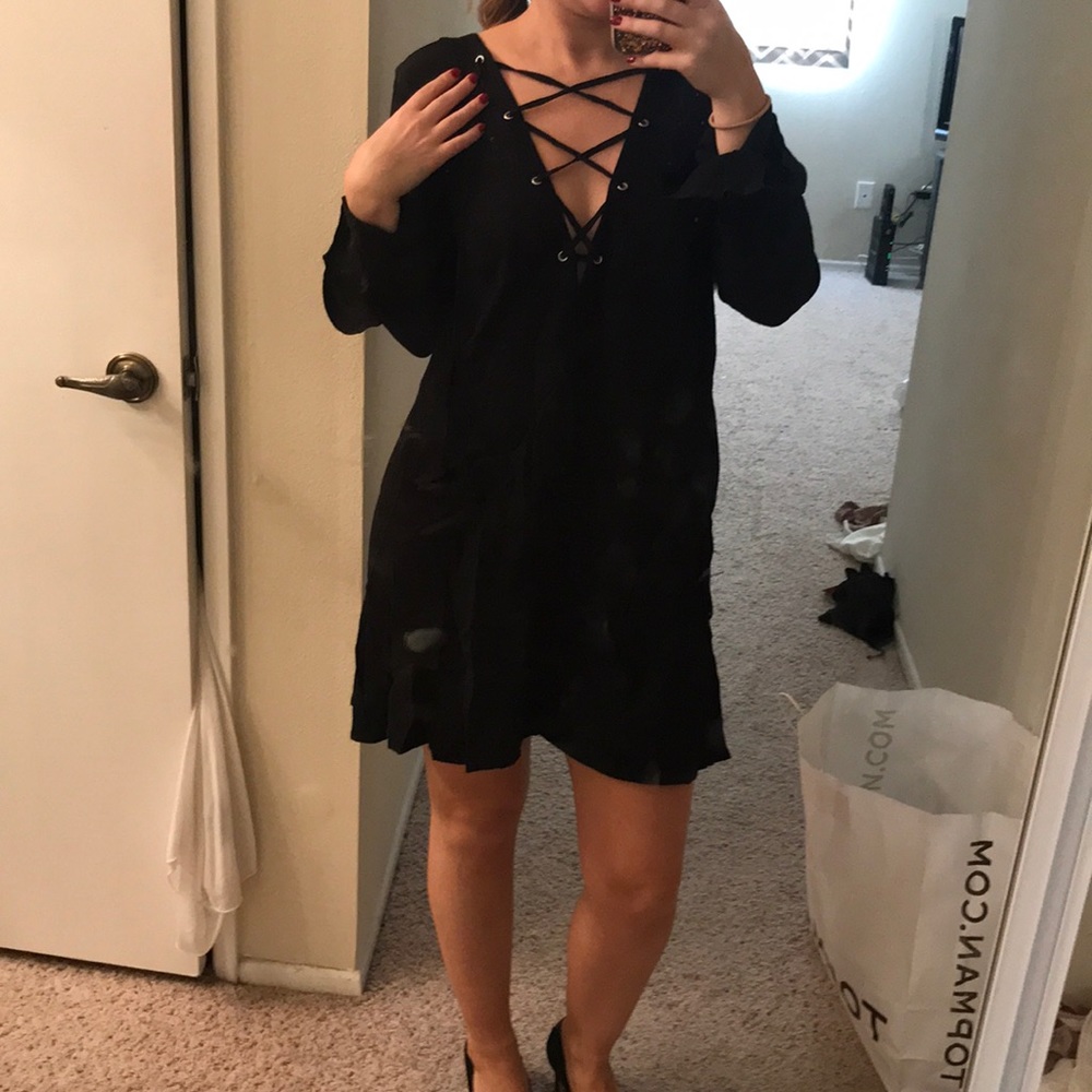 Long bell sleeved lace up mini dress.