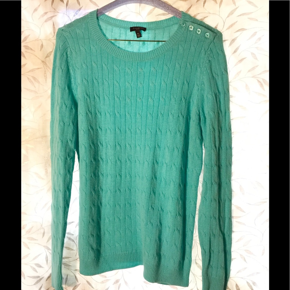 Turquoise sweater with buttons on left shoulder.