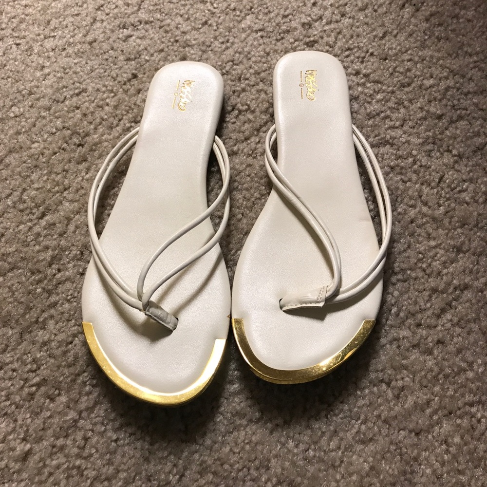 White flip flops with gold accents