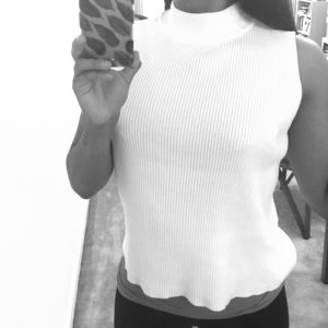 White turtle neck, sleeveless shirt.