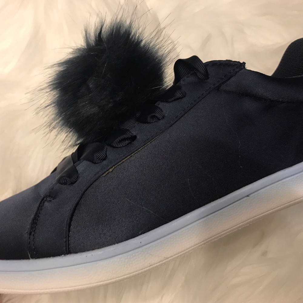 Navy satin shoes with a fluffy ball.
