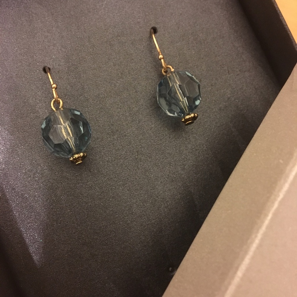 Gold-colored dangling light blue charm earrings