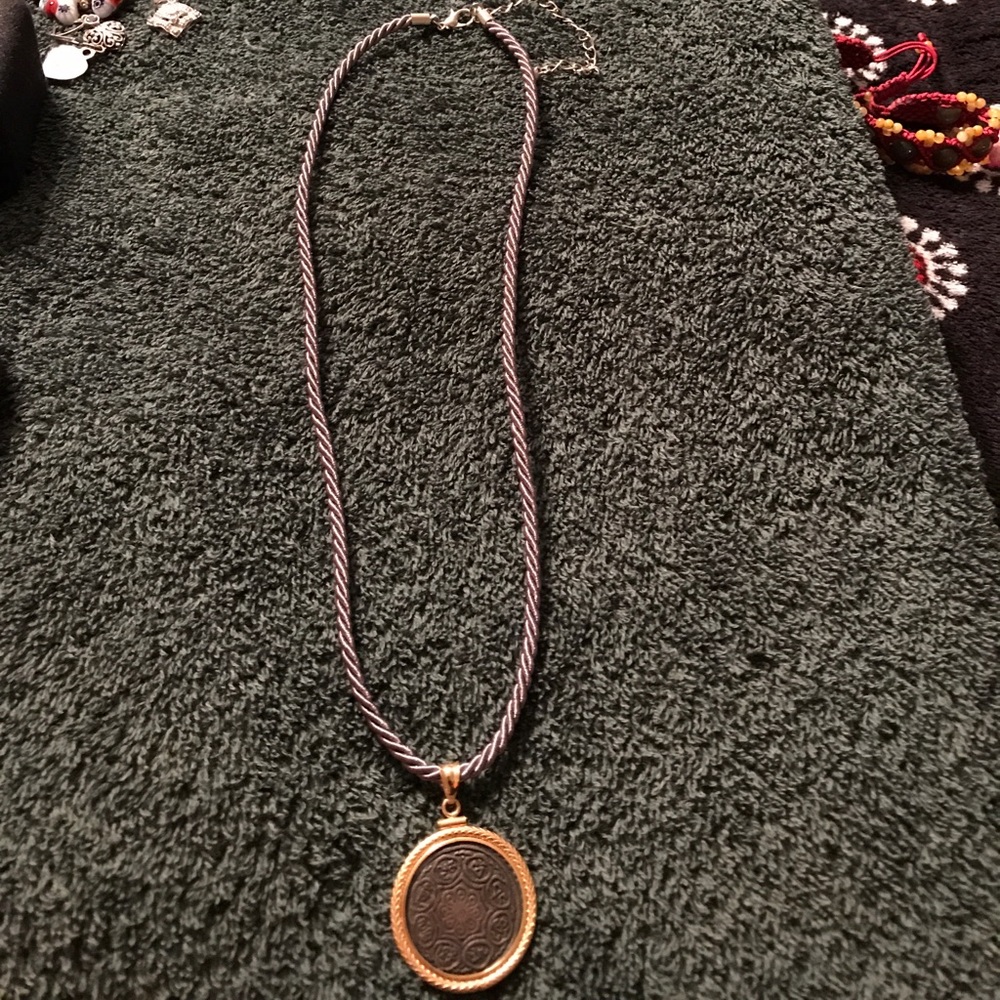 Gold coin pendant on silver chord