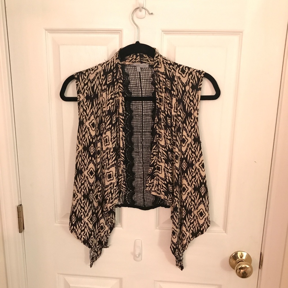 Sleeveless cardigan with crocheted back.