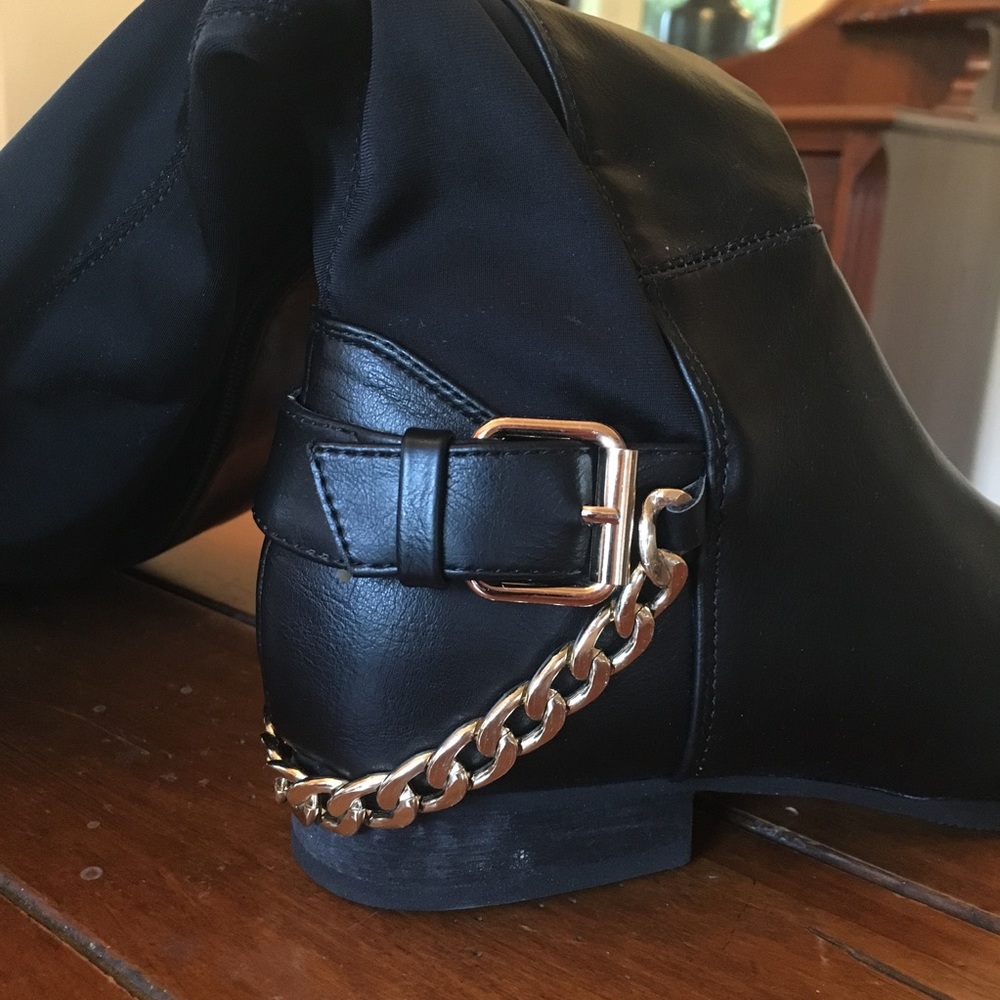 Black boots with decorative buckle and gold chain