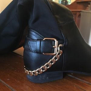 Black boots with decorative buckle and gold chain