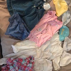 Baby new born clothes along with pampers.