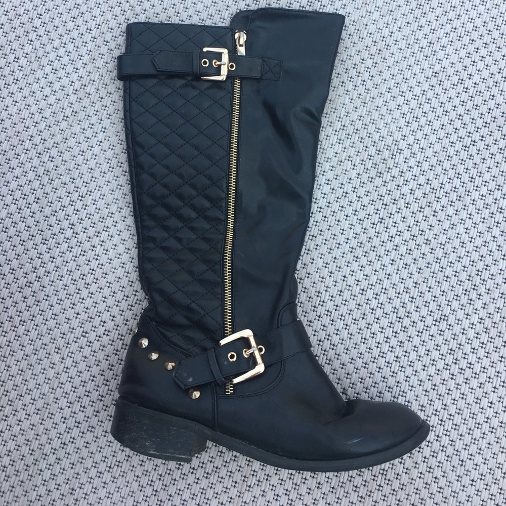 Knee high black riding boots with gold accents