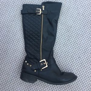 Knee high black riding boots with gold accents