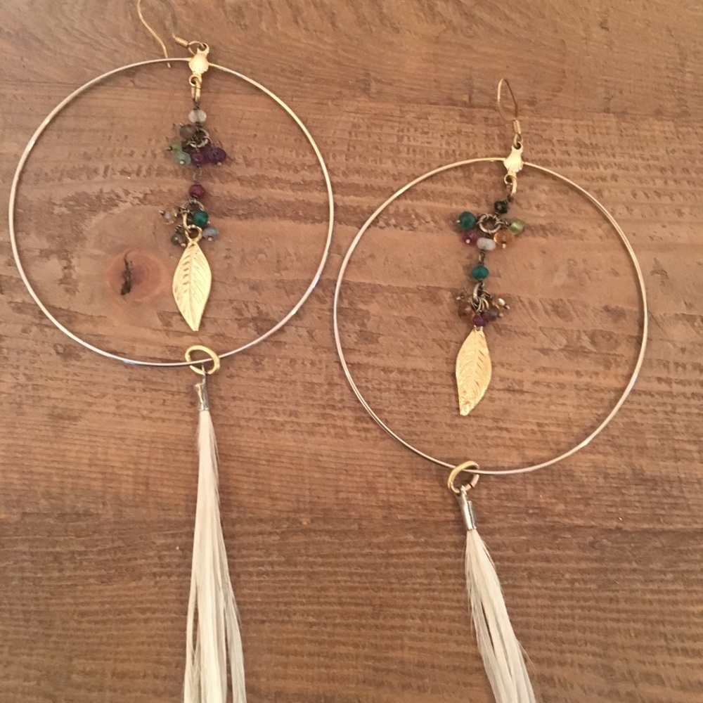Feather and gold hoop earrings by Ettika