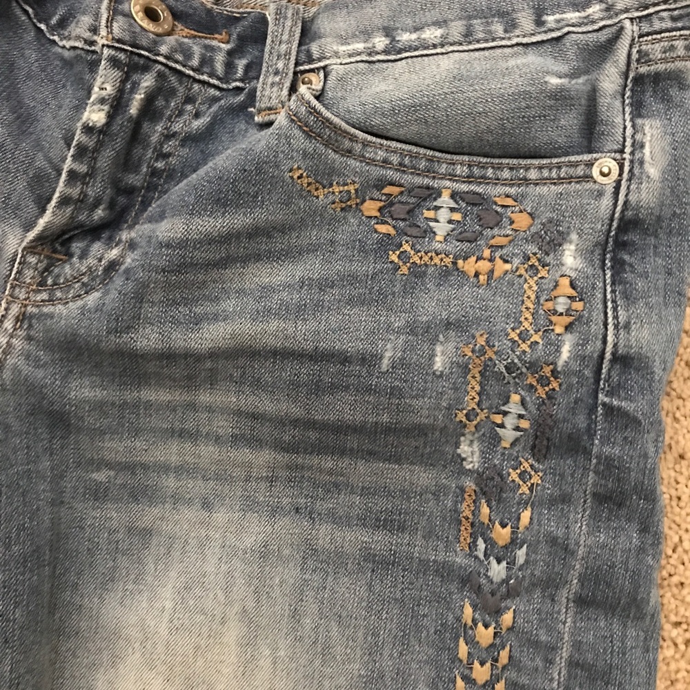 Slightly distressed embroidered jean shorts.
