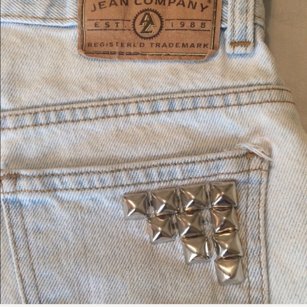 Classic destroyed denim cutoffs with silver studs.