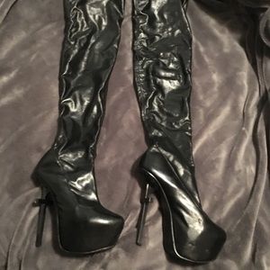 Thigh high black platform boots with cross heal.