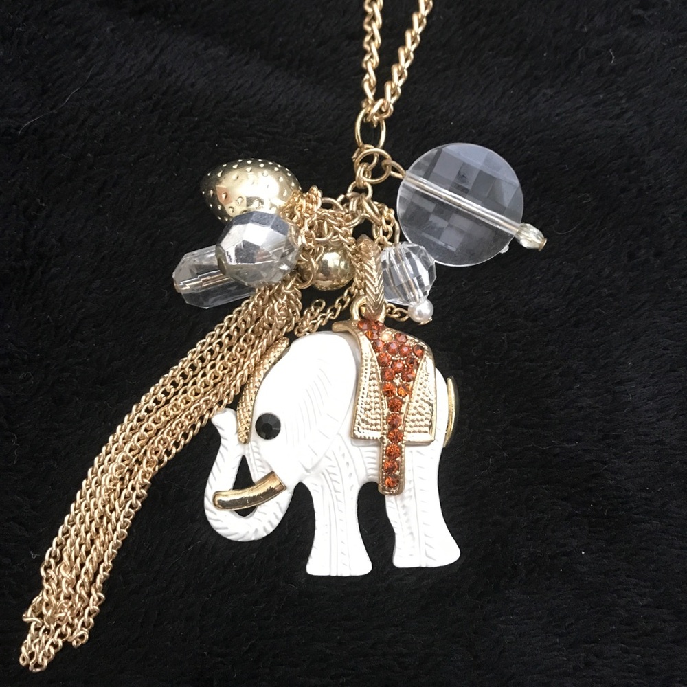 Long gold necklace with a off white elephant