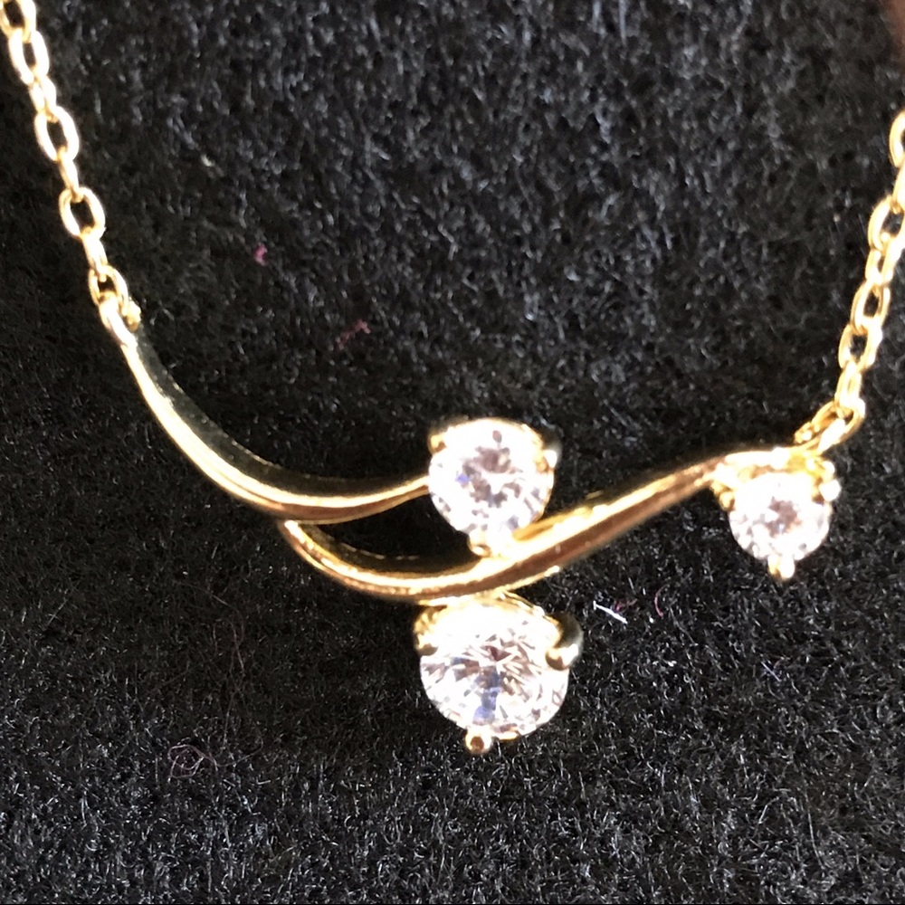 Gold tone three cubic zirconia necklace.