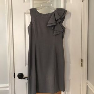 Grey dress with ruffle detail at the shoulder.