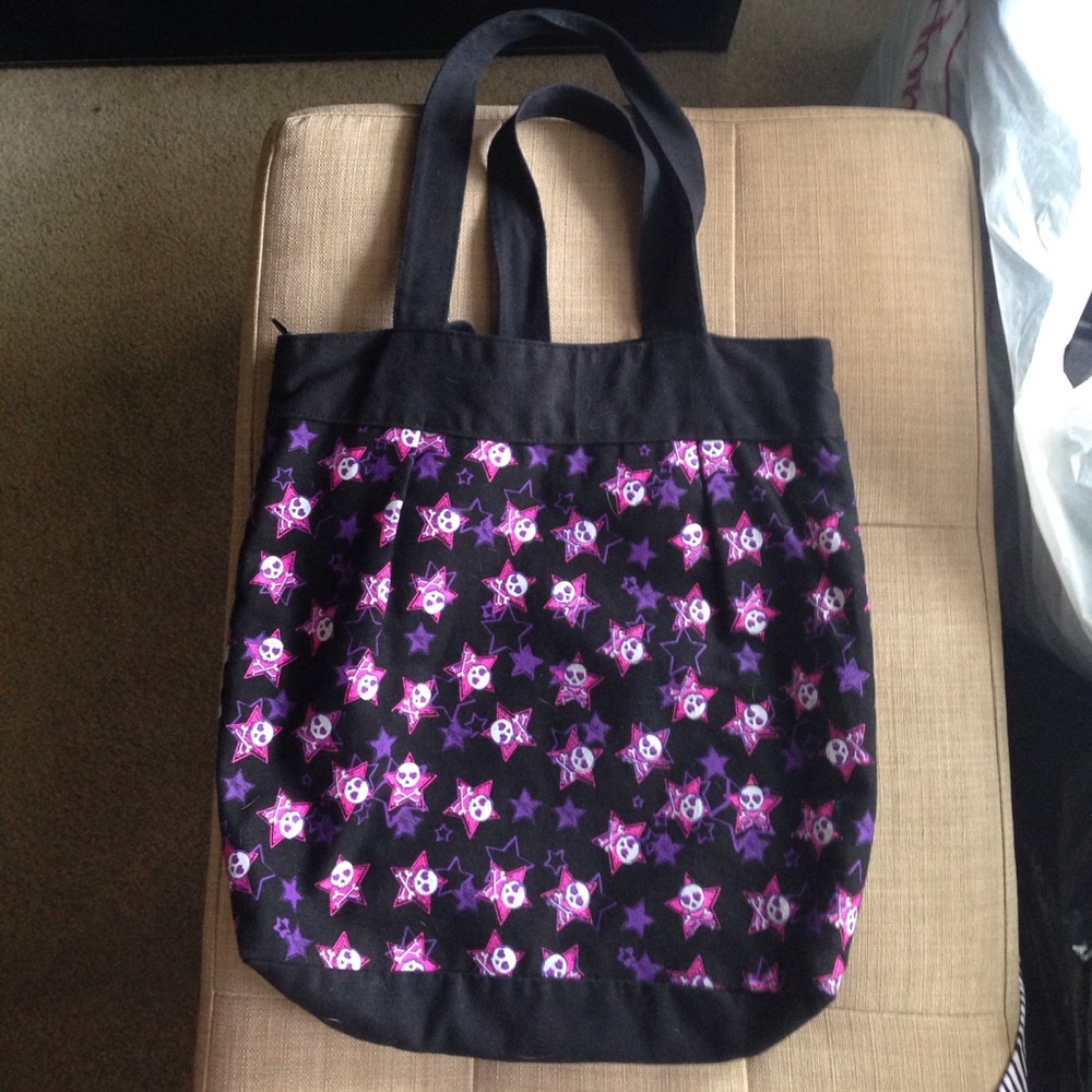 Black tote bag with skull/crossbones, pink/purple