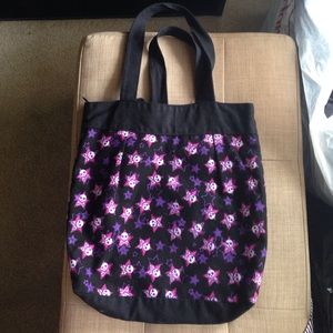 Black tote bag with skull/crossbones, pink/purple