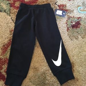 Black nike pants, white nike Stripe.