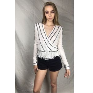 Long sleeve white top with black trim designs