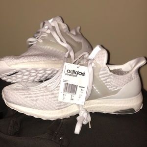 White Adidas Ultraboost tennis shoes.
