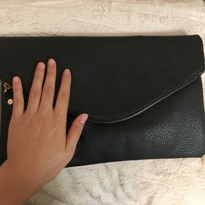 Black faux-leather clutch with tassels