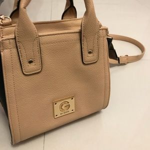 A beige cross body bag from Guess