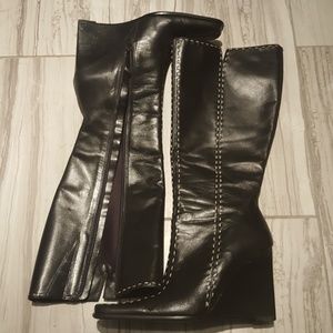 Black leather wedge boots with white stitching.