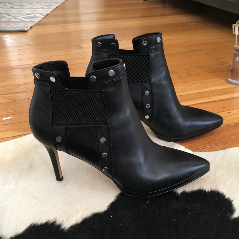 Black leather pointed booties with metal detail.