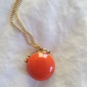 Gold necklace with orange circle locket. Gold necklace with orange circle locket.