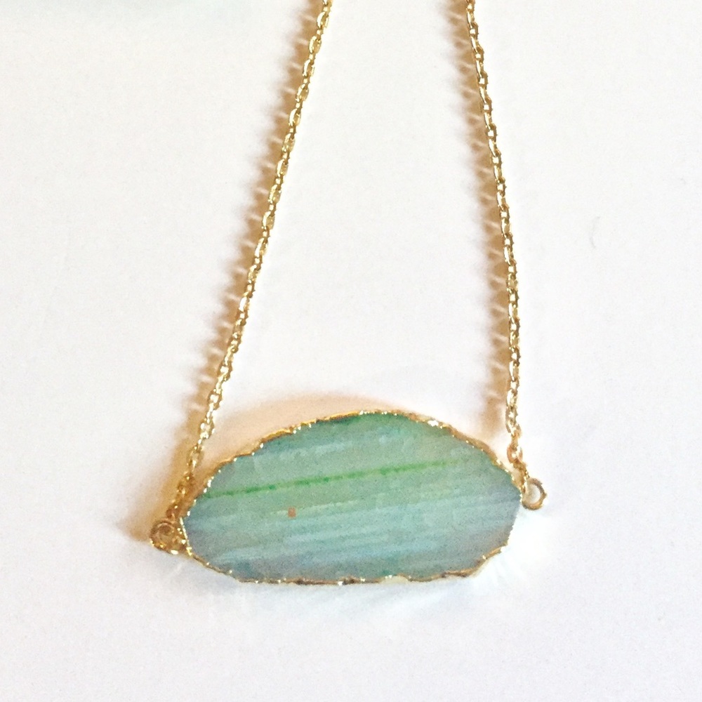 Green stone necklace with gold detailing.