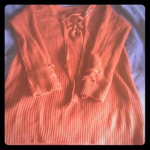 Long burnt orange sweater-like shirt.