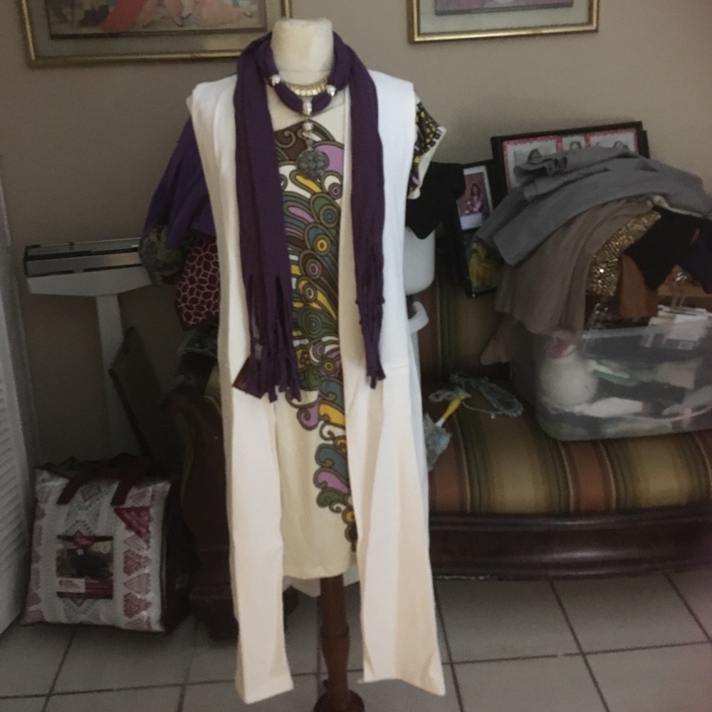 A biege white color long sleeve less jacket