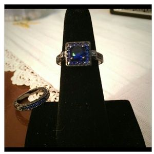 Black gold plated ring set with square cut blue sa