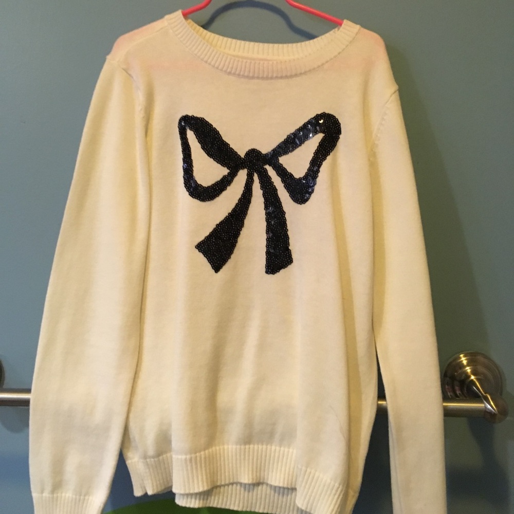 White sweater with black sequined bow