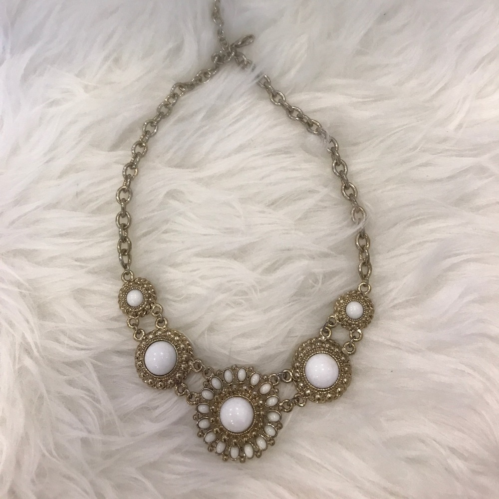 White ornament with gold chain necklace