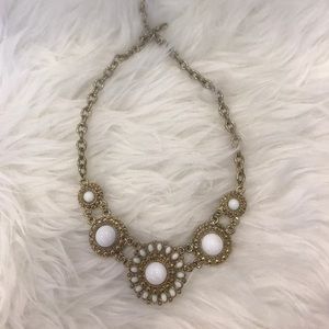 White ornament with gold chain necklace