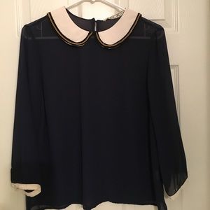 Navy top with white bib and gold chain accent