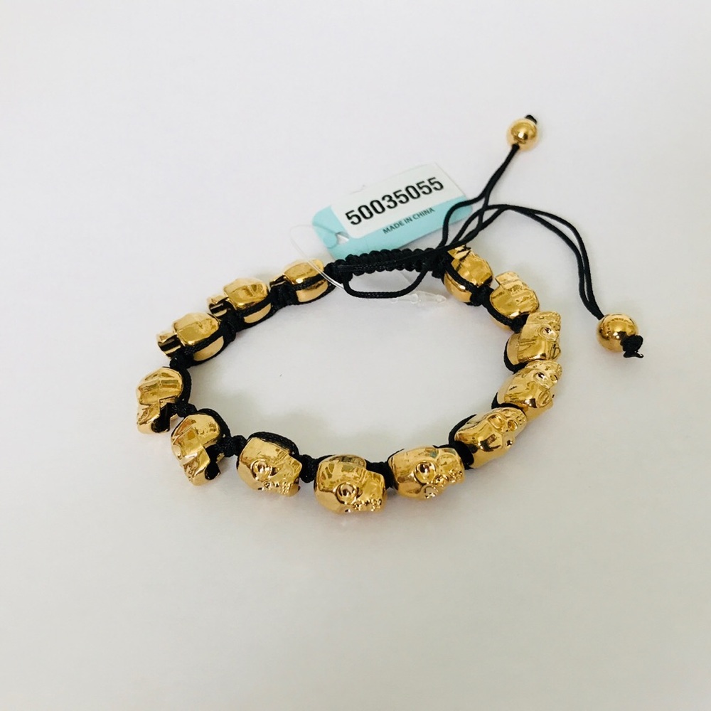 Golden skull bracelet with adjustable black cord