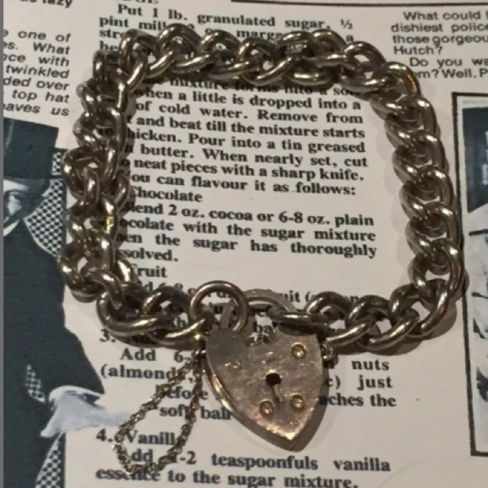 A HEAVY VINTAGE STERLING SILVER CHARM BRACELET
