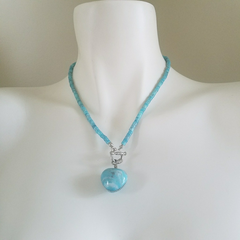 Turquoise colored necklace with stone.