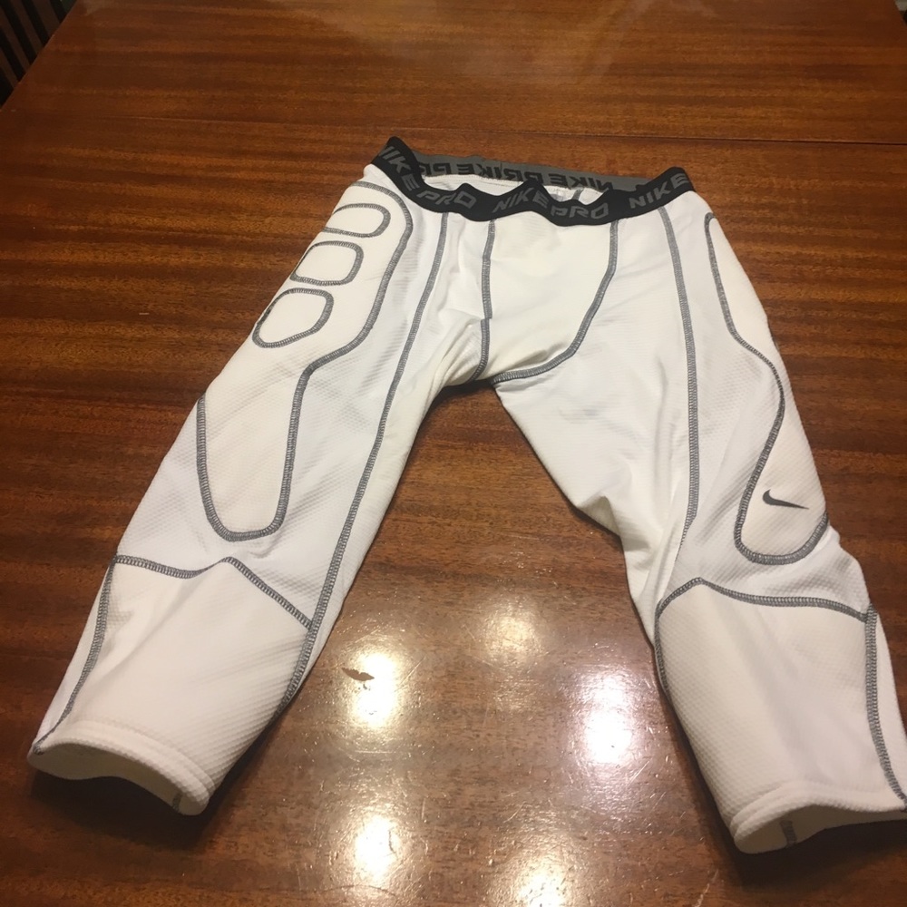 Med white Nike padded football shorts.