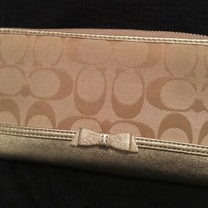 Khaki Coach wallet with bow & gold trim.