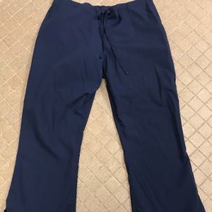 Four pairs of navy scrub drawstring pants.