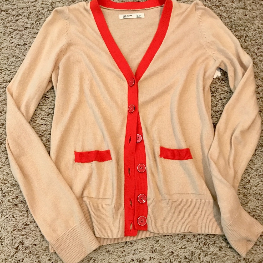 Tan cardigan with orange trim.